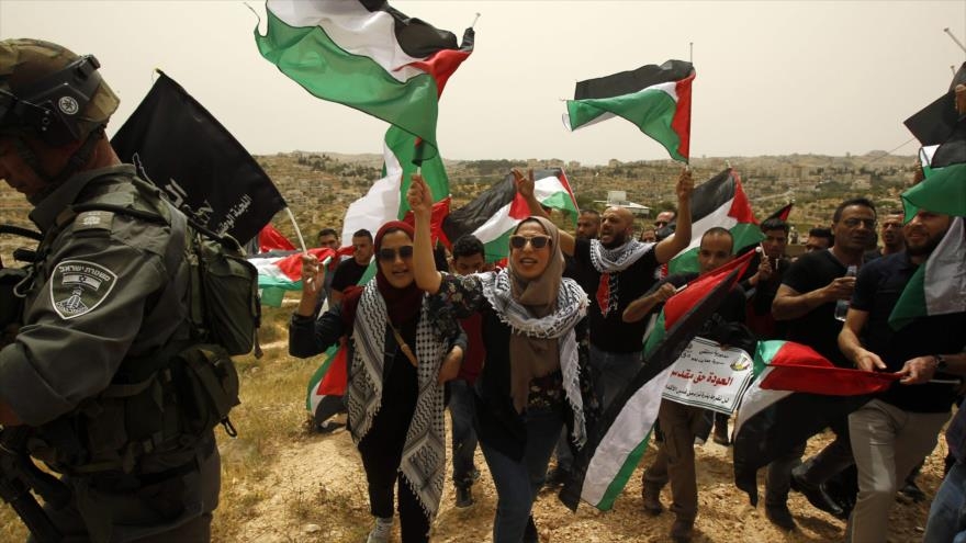 Palestinos marchan cerca del valle fronterizo entre Al-Quds (Jerusalén) y Belén 10 de marzo de 2018.