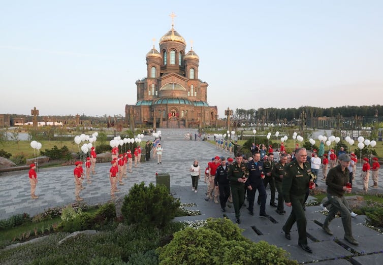 Miembros de las fuerzas armadas caminan frente a una catedral en Rusia durante una ceremonia