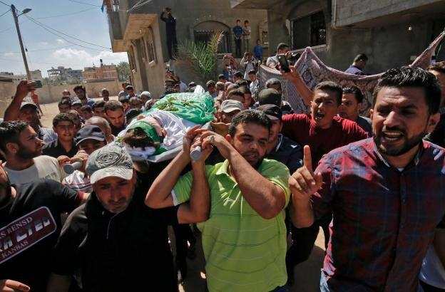 Un grupo de palestinos porta el cadáver de Mumin Abú Ayeda, un joven de 15 años muerto ayer durante las protestas en la frontera de Gaza. /  AFP